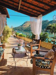 曼加拉蒂巴科斯塔克雷斯旅馆的一个带椅子的庭院,享有水景