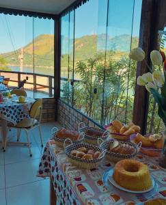 曼加拉蒂巴科斯塔克雷斯旅馆的一张桌子,上面放着一篮面包,享有美景