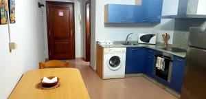 卡尔达斯·德·雷斯Apartamento Loft II Select Real Caldas de Reis的厨房配有桌子和洗衣机。