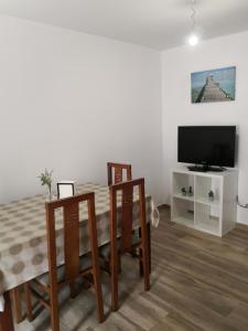 波多诺伏Apartamento en casa Portonovo vacaciones的客厅配有桌椅和电视。