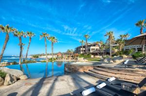 卡波圣卢卡斯Esperanza, Auberge Resorts Collection的棕榈树游泳池及度假村
