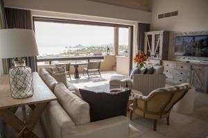 卡波圣卢卡斯Esperanza, Auberge Resorts Collection的带沙发和椅子的客厅以及大窗户。