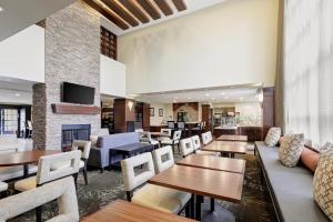 拉纳姆Staybridge Suites Washington D.C. - Greenbelt, an IHG Hotel的一间带桌椅和壁炉的餐厅