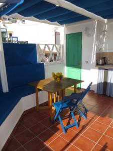 莫甘海滩Captains House Playa De Mogan的一间带桌子和蓝色椅子的用餐室
