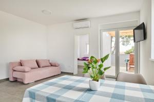 乌马格Apartmani Ivana的客厅配有桌子和粉红色的沙发