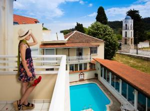 萨索斯费洛克森尼亚酒店的站在泳池景阳台上的女人