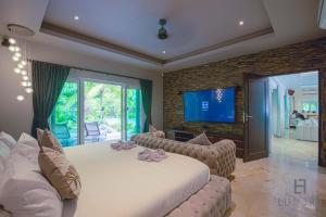 七岩6 Bedroom Luxury Villa on Golf Course PH125的一间带大床和电视的卧室