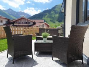 贝旺Alpenflair的庭院配有椅子和桌子及盆栽植物