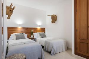 亚伊萨Villa Acacia的白色墙壁客房的两张床