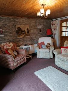 RingsendCarnowen Cottage的客厅配有两把椅子和一张沙发