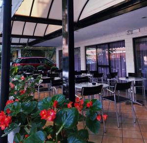 里米尼苏西酒店的一间带桌椅和红花的餐厅
