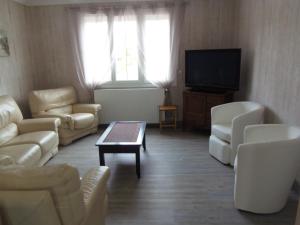 格朗德康迈西maison de vacances的客厅配有白色家具和平面电视