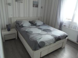 格朗德康迈西maison de vacances的卧室配有一张带白色和黑色棉被的床