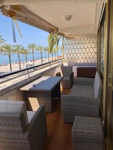 卡拉费尔Face à La Mer的一间设有桌椅的餐厅,享有海滩美景