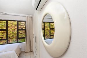 德班14 The Shades - by Stay in Umhlanga的卧室设有窗户,配有白色镜子