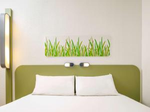 卡迪夫迪夫中心宜必思快捷酒店的一张带绿床头板的床铺,上面有一张草图