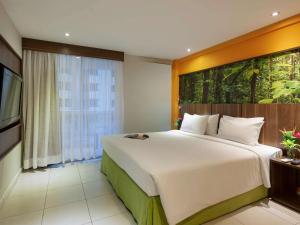新伊瓜苏Mercure Rio de Janeiro Nova Iguaçu的一间卧室设有一张大床和一个大窗户