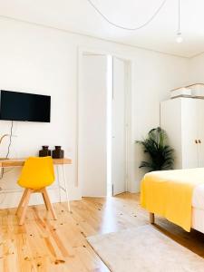 波尔图Guest House Arca d´'Água的白色卧室配有黄色椅子和书桌