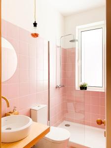 波尔图Guest House Arca d´'Água的粉红色的浴室设有浴缸和水槽