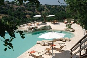 栋纳富加塔罗莱斯帕可卡瓦罗加酒店的一个带椅子和遮阳伞的游泳池