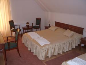 米什科尔茨Várkert Panzió的卧室配有一张带桌椅的大床