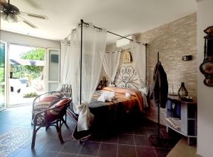 卡斯蒂里昂纳·德拉佩Poggio Mariett的一间卧室配有一张天蓬床和一把椅子