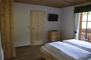 阿特湖畔施泰因巴赫Haus Stückler的一间卧室设有两张床,墙上配有电视。