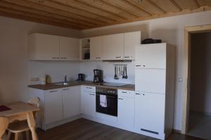 阿特湖畔施泰因巴赫Haus Stückler的厨房配有白色橱柜和白色冰箱。
