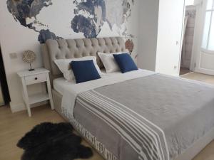 敖德萨Dom Rabinovicha的一间卧室配有一张带蓝色枕头的大床