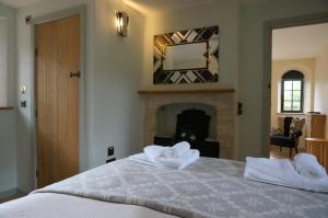 DyrhamGatekeepers Lodge, Dyrham Park - Private & Self Contained, deluxe accommodation, 15 mins from Bath的一间卧室配有带毛巾的床