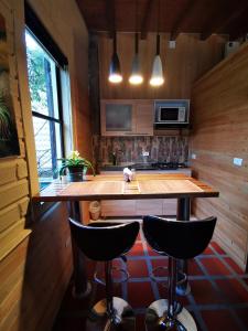 瓜尔内CABAÑAS MONTEVERDE - Guarne ANT的厨房配有一张大木桌和两张酒吧凳