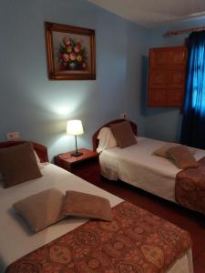 Vall dʼAlba勒尔米塔卡萨里波酒店的一间卧室配有两张床、一盏灯和一张地毯。