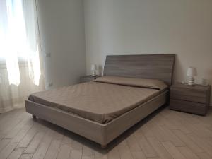 菲乌米奇诺Fiumicino Dream & Fly 2的一间卧室配有一张带2个床头柜和2盏灯的床。