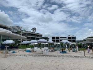 华欣Santorini Khao Takiab Huahin Beach Front的海滩上的蓝白遮阳伞