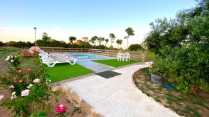 卡拉索纳CAN DAMIA 1的后院,带游泳池、长凳和鲜花