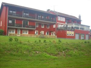 Holsthum欧罗巴酒店的前面有绿地的红色建筑