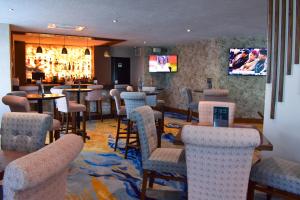 瓜达拉哈拉波托韦洛酒店的酒吧设有桌椅和电视