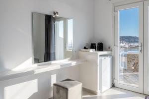 米克诺斯城Magic View Suites Mykonos的白色的房间,设有窗户和凳子