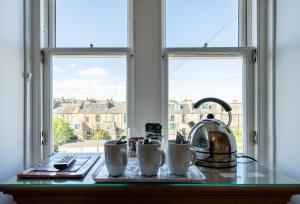 爱丁堡金斯利旅馆的窗户上的桌子,桌子上装有杯子和茶壶