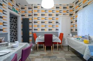 爱丁堡金斯利旅馆的一间设有两张桌子和图案墙壁的用餐室
