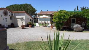 普林希匹纳马尔Agriturismo Prato Verde的庭院设有房屋和遮阳伞