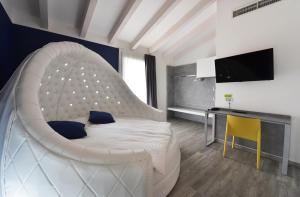 加尔达湖滨Primavera ApartmentSuites的卧室配有一张白色大床和一张书桌