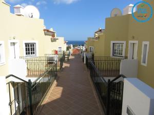 珀彻斯Apartamento T1 com vista mar perto da Praia N.ª Sra. da Rocha的两栋带围栏的建筑之间的人行道