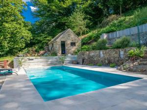 韦尔维耶Charming, cosy renovated farm in Les Houches的一座位于后院的游泳池,后院设有石屋