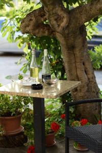 沃迪切Studio apartman MARINA的两瓶葡萄酒放在树旁的桌子上