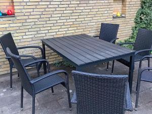 Hesselbjerg6 person holiday home in Nyk bing M的一张黑桌子和椅子以及一张桌子和椅子