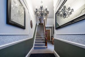哈罗盖特Fountains Guest House - Harrogate Stays的走廊上设有吊灯的楼梯
