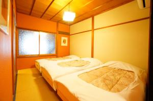 高山Momiji Takayama的带2扇窗户的客房内的2张床