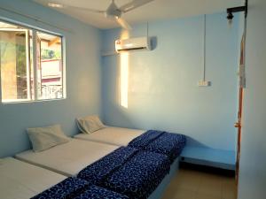 邦咯邦咯渔家的蓝色的客房设有床和窗户。