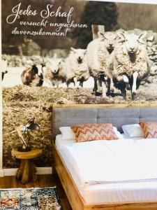 巴德贝芬森Hotel Pension Fortuna的卧室配有一张床和一幅羊画